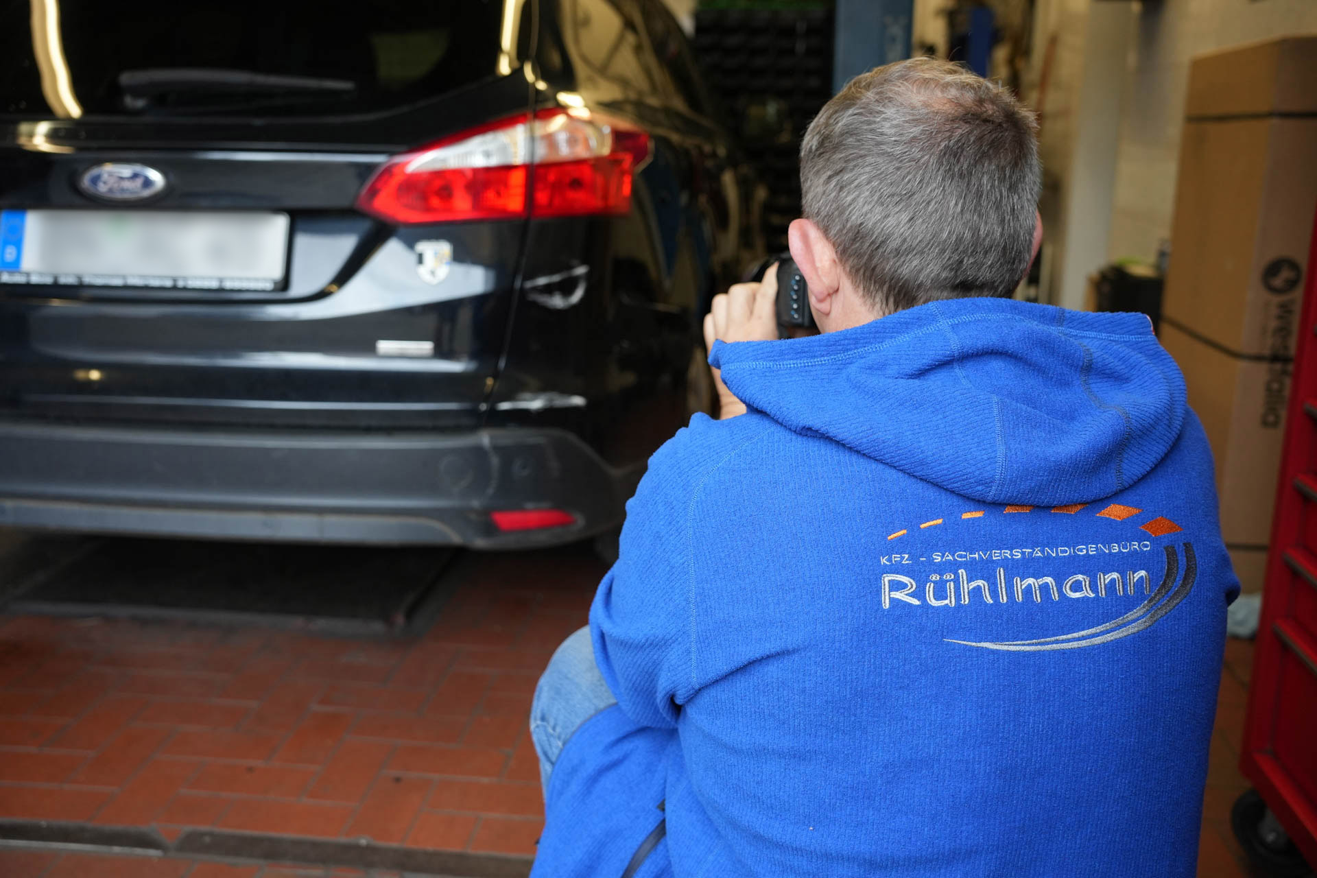 Kfz-Sachverständiger bei der GTÜ-Partnerstelle in Bonn während der Hauptuntersuchung und Fahrzeugbewertung für ein Kfz-Gutachten