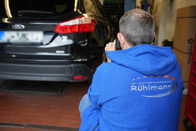 Kfz-Gutachter bei der Begutachtung eines Unfallfahrzeugs vor Ort